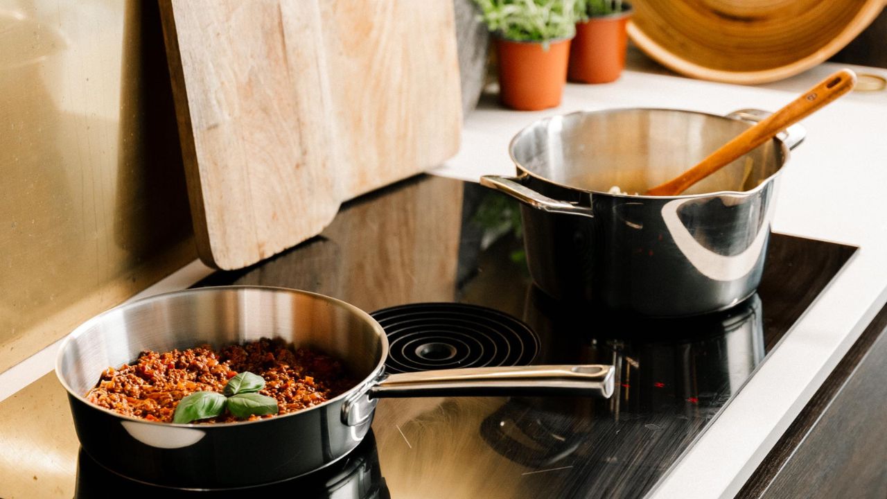 Miljøbillede af gryde og pande i rustfrit stål fra Chefgrade serien fra Qookware placeret på kogeplade