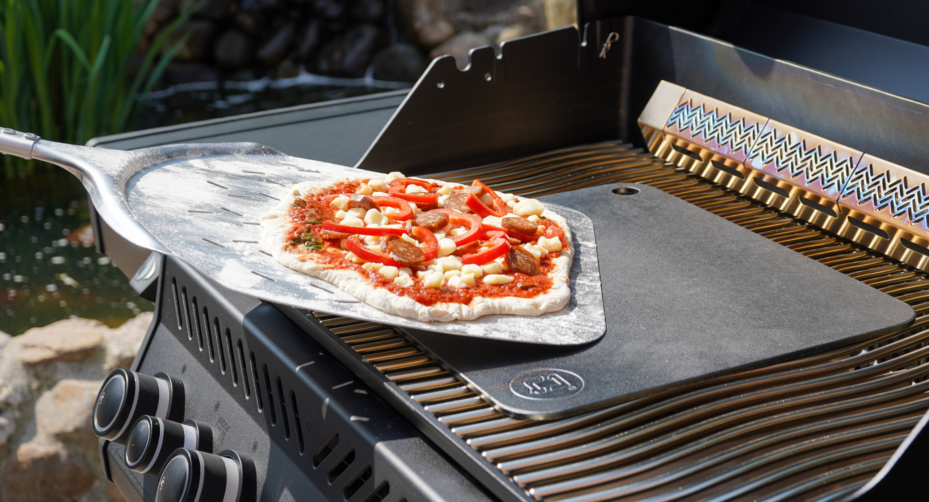 Bagning af pizza på et bagestål på gasgrill 