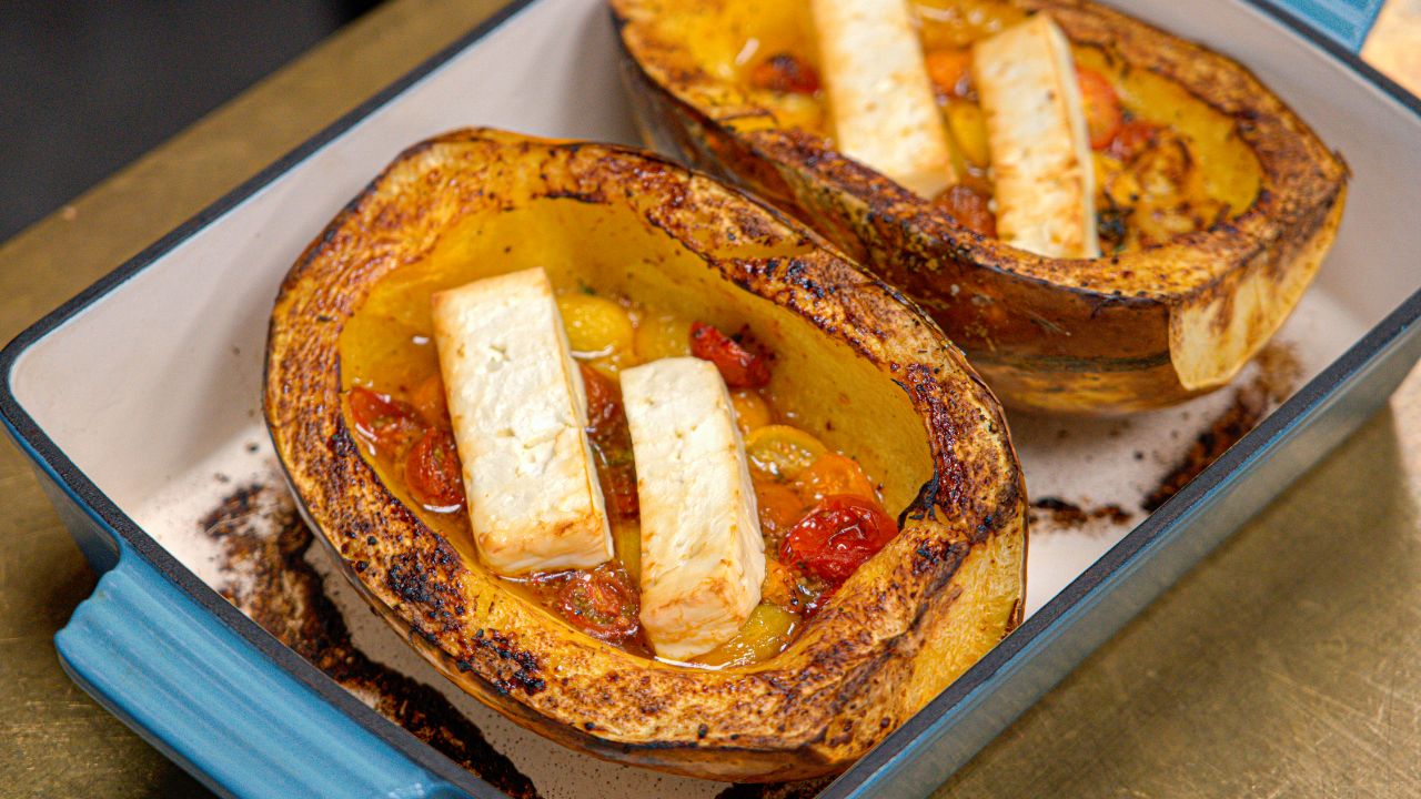 Bagt spaghetti squash med feta og cherry tomater anrettet i emaljeret støbejernsfad