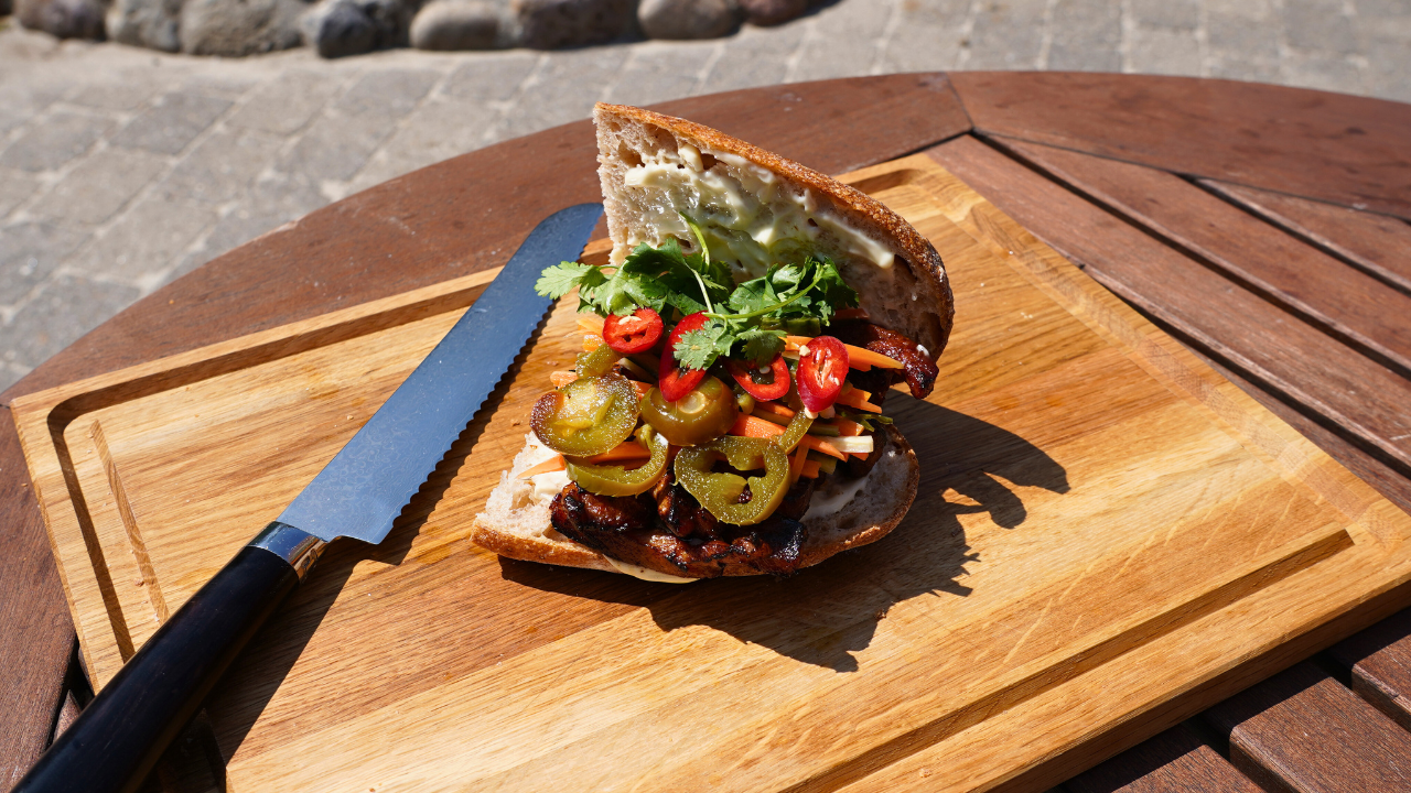 Anretning af Banh mi sandwich på skærebræt i egetræ