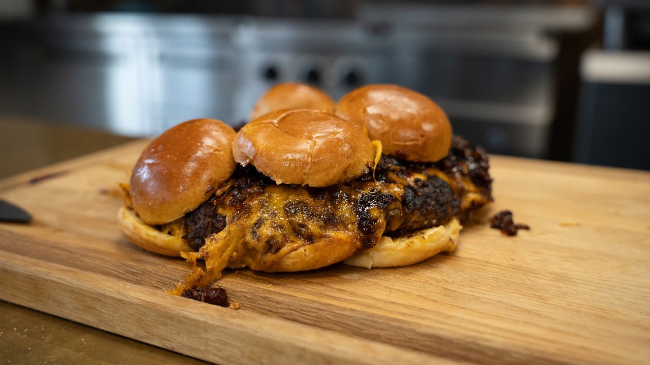 Anretning af bruger sliders med ost på skærebræt i egetræ