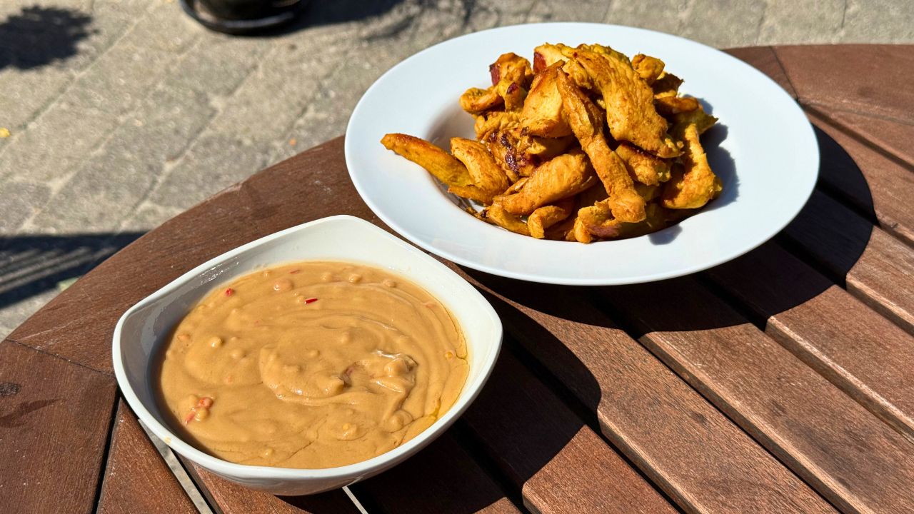 Chicken satay med jordnøddesauce anrettet på havebord ved grill
