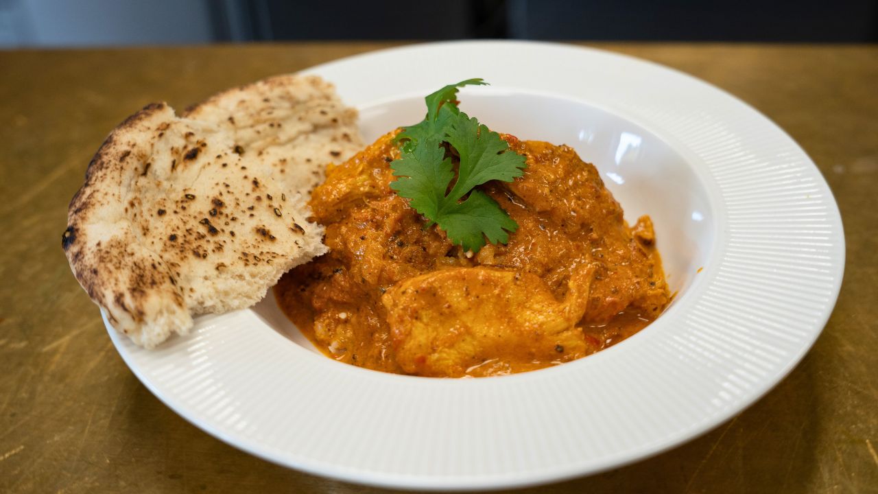 Chickentikka masala med ris og naan anrettet i dyb tallerken 