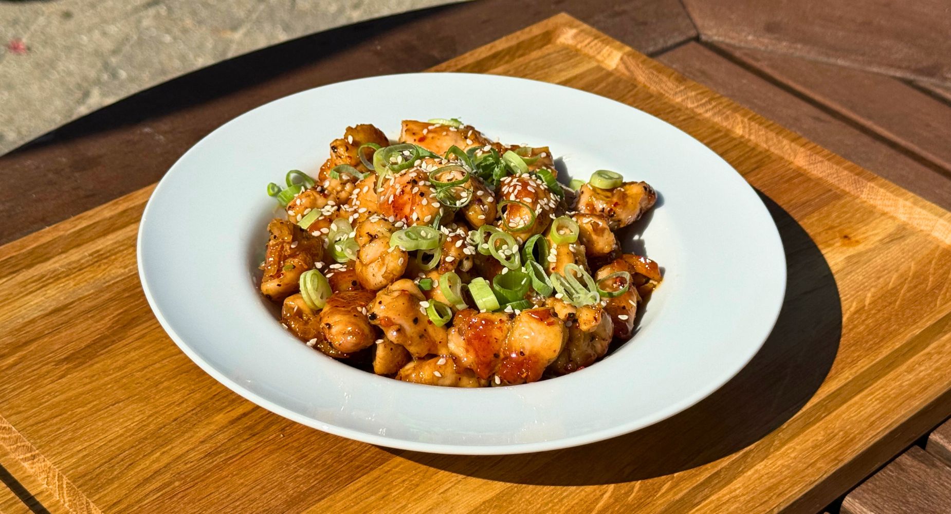 Honey butter chicken anrettet i dyb tallerken udendørs ved grill