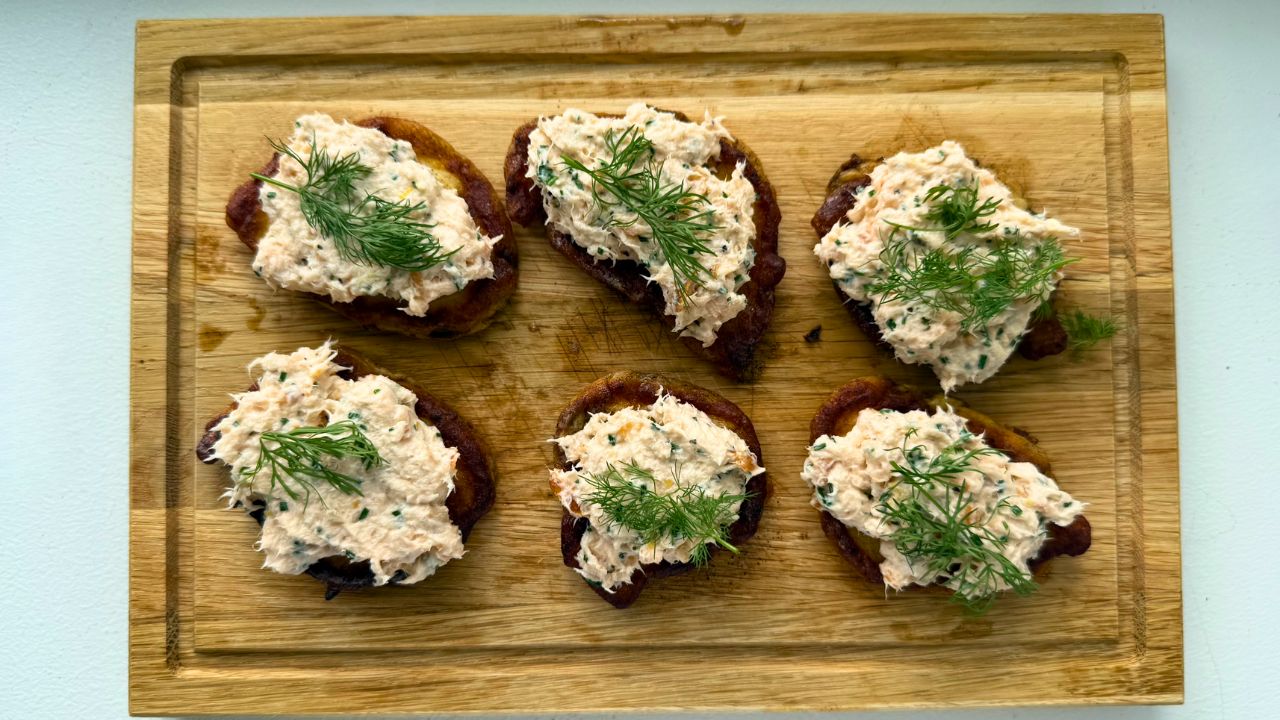 Potato blinis with smoked salmon mousse, pickled cucumber and rye bread crunch