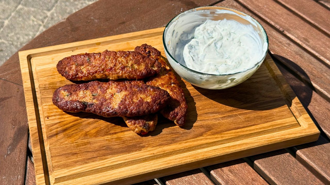 Kyllingkofta med friske krydderurter og yoghurtdressing anrettet på skærebræt 