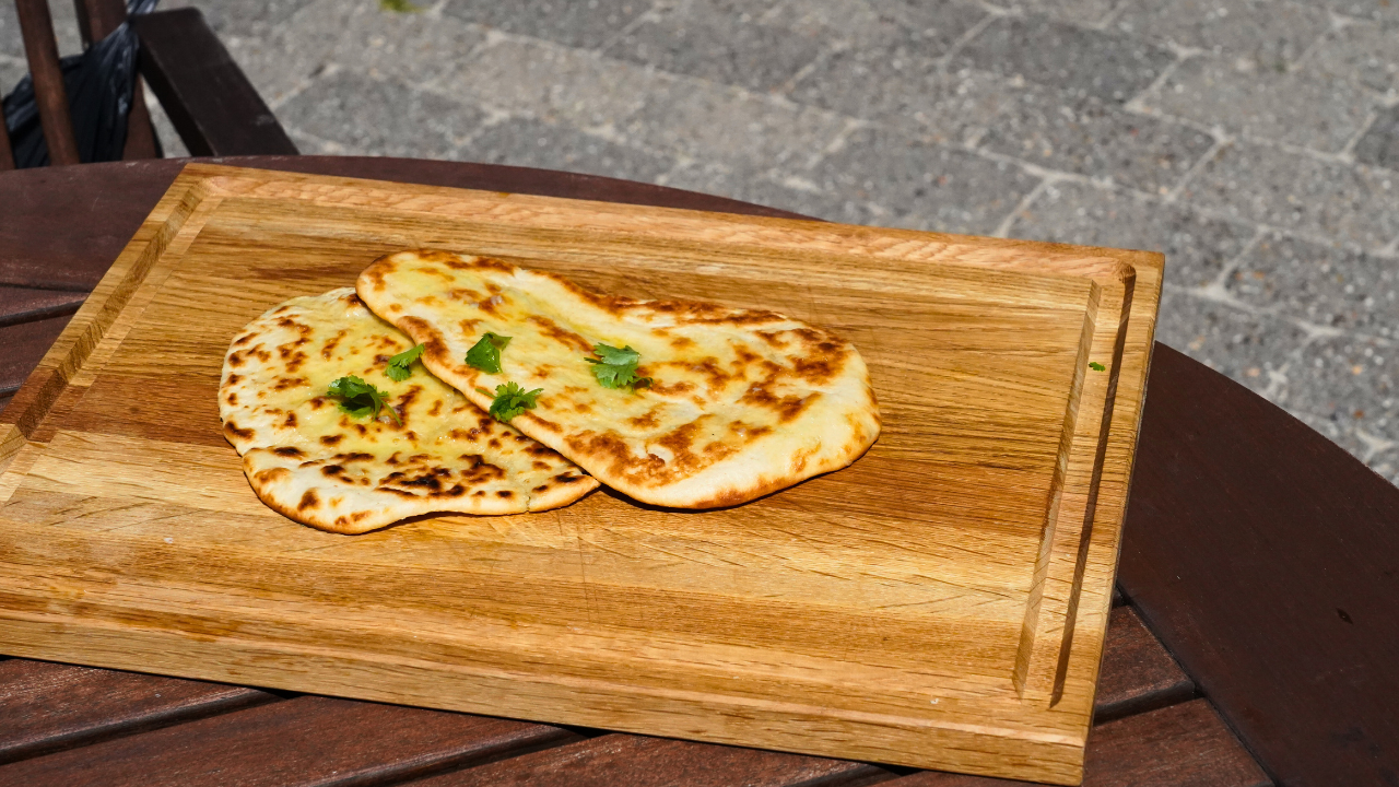 Naanbrød lavet på grillen og anrettet på skærebræt 