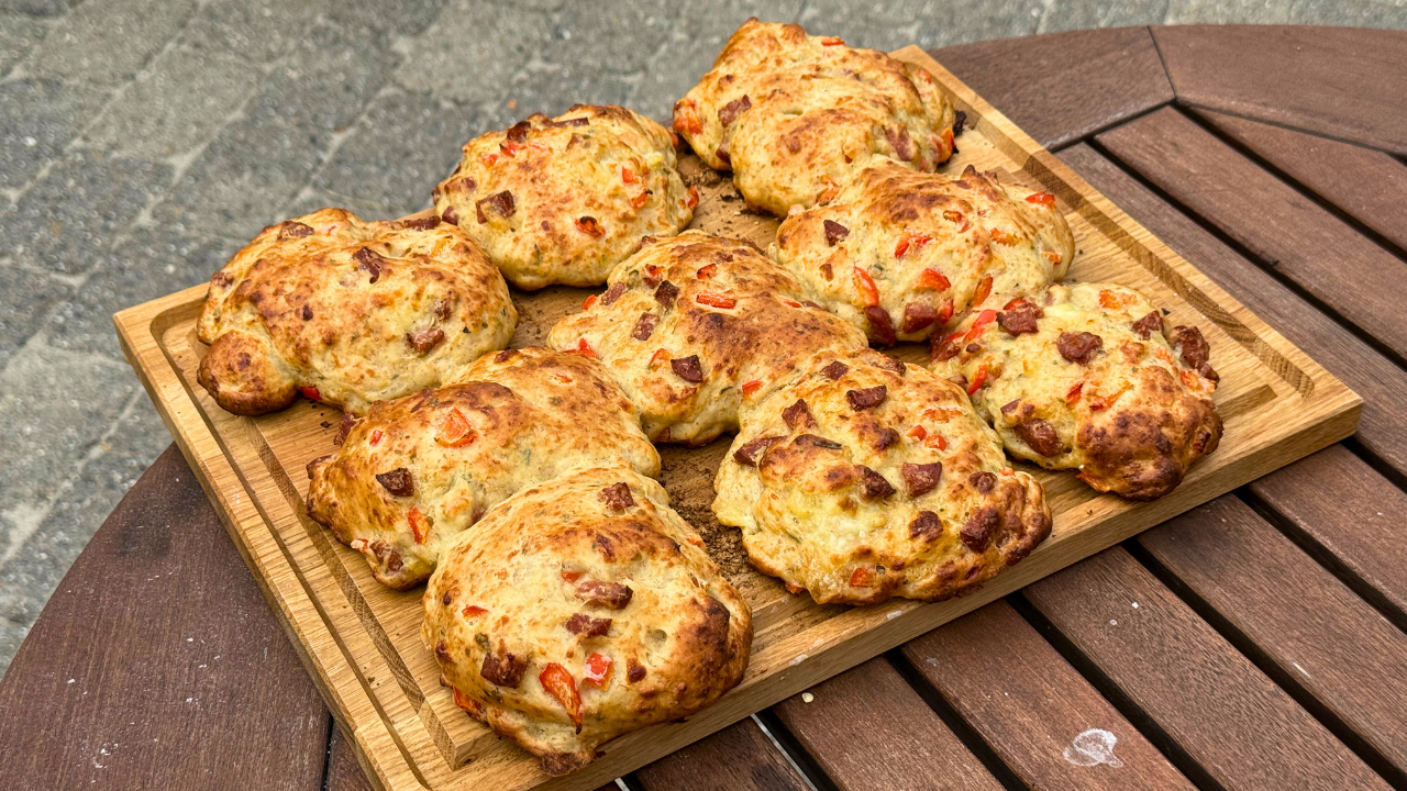 Pizzabrud med chorizo og rød peber anrettet på stort skærebræt i egetræ 
