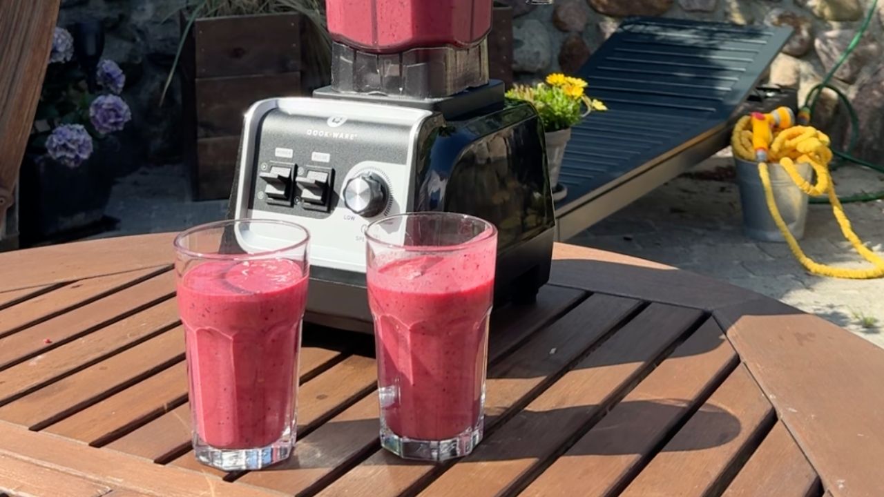Rød smoothie i blender anrettet i glas 